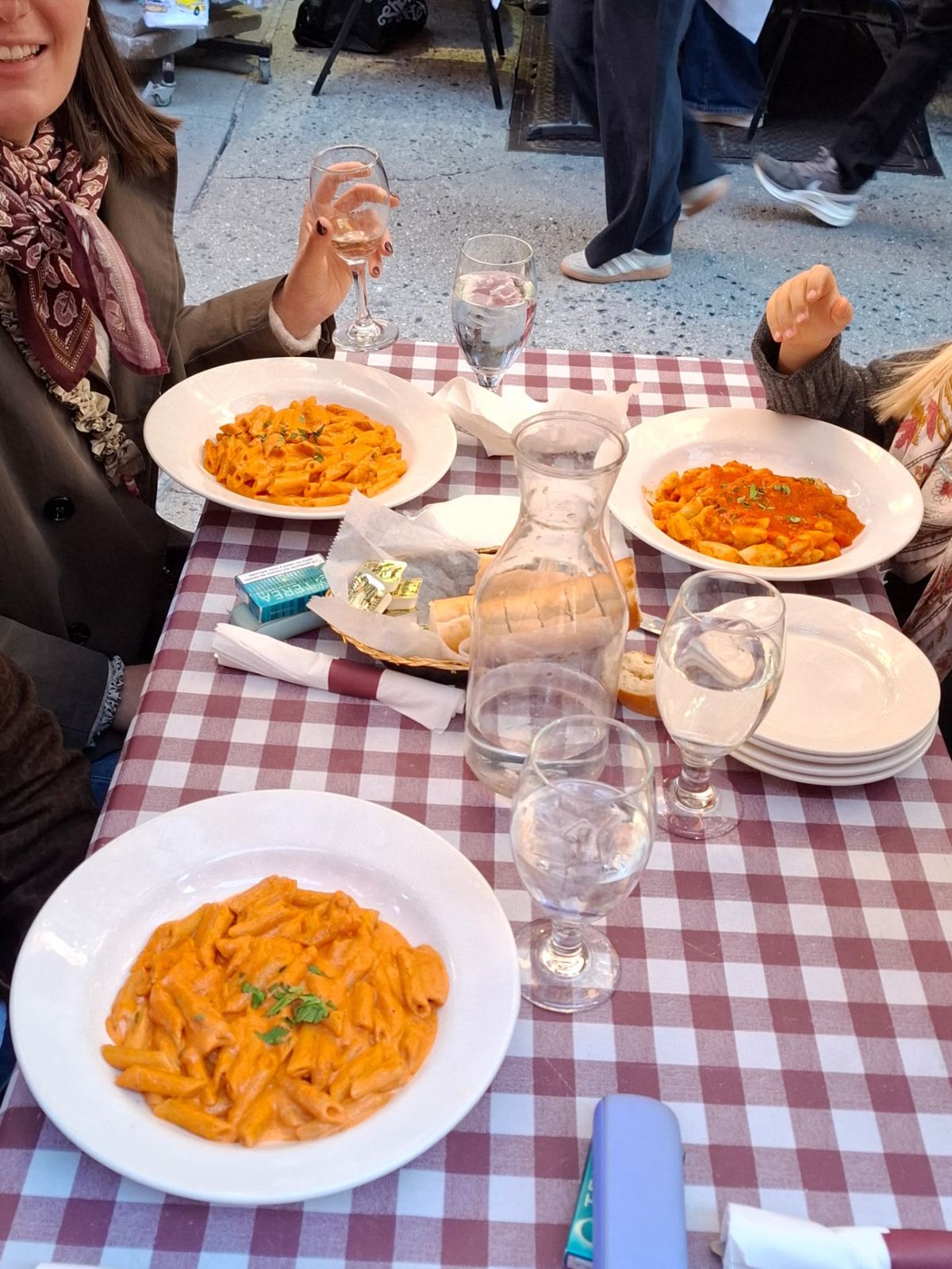 Several pasta dishes arranged on a red checkered dining table