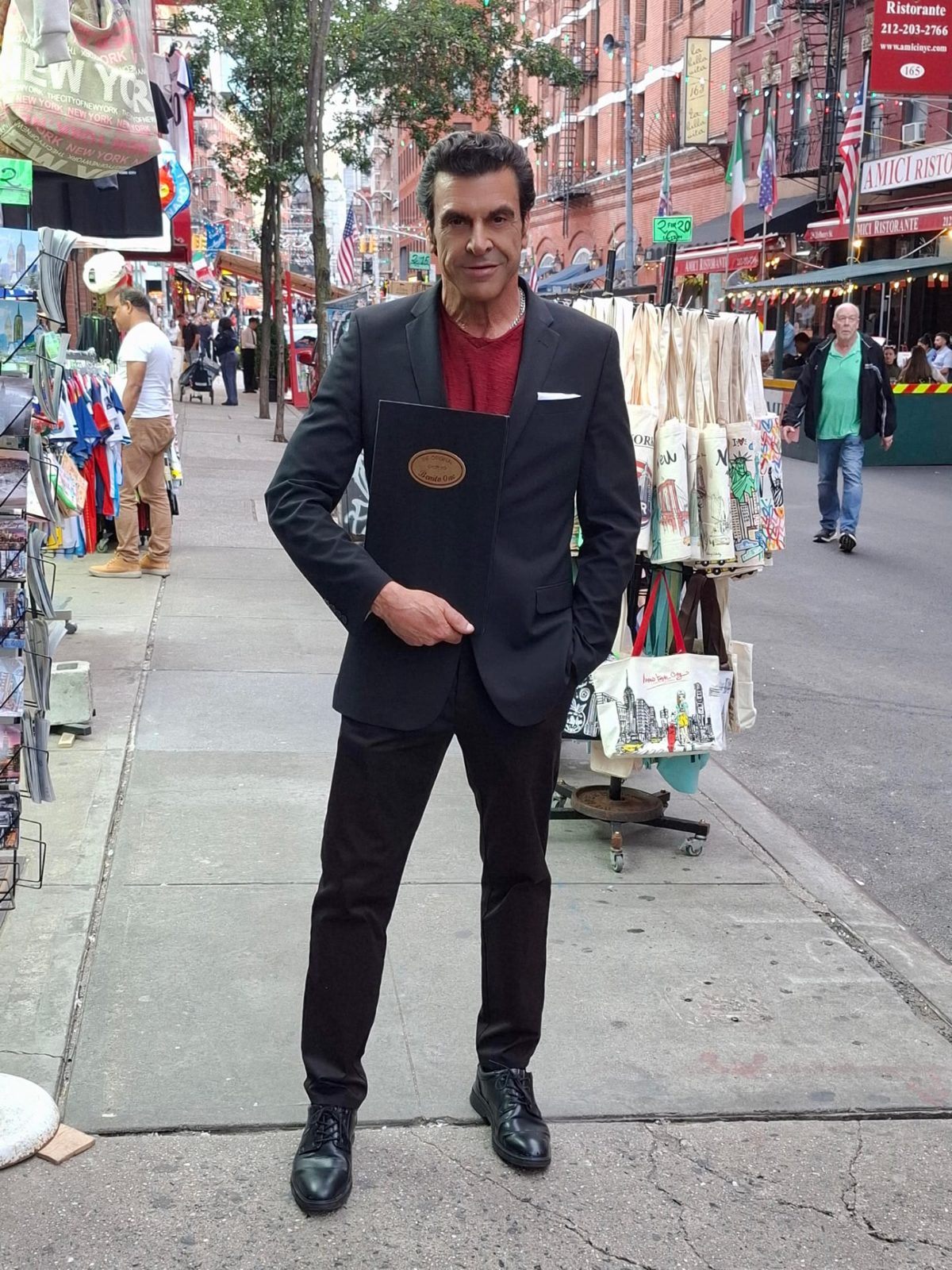 A guest posing on the Little Italy sidewalk outside Benito One