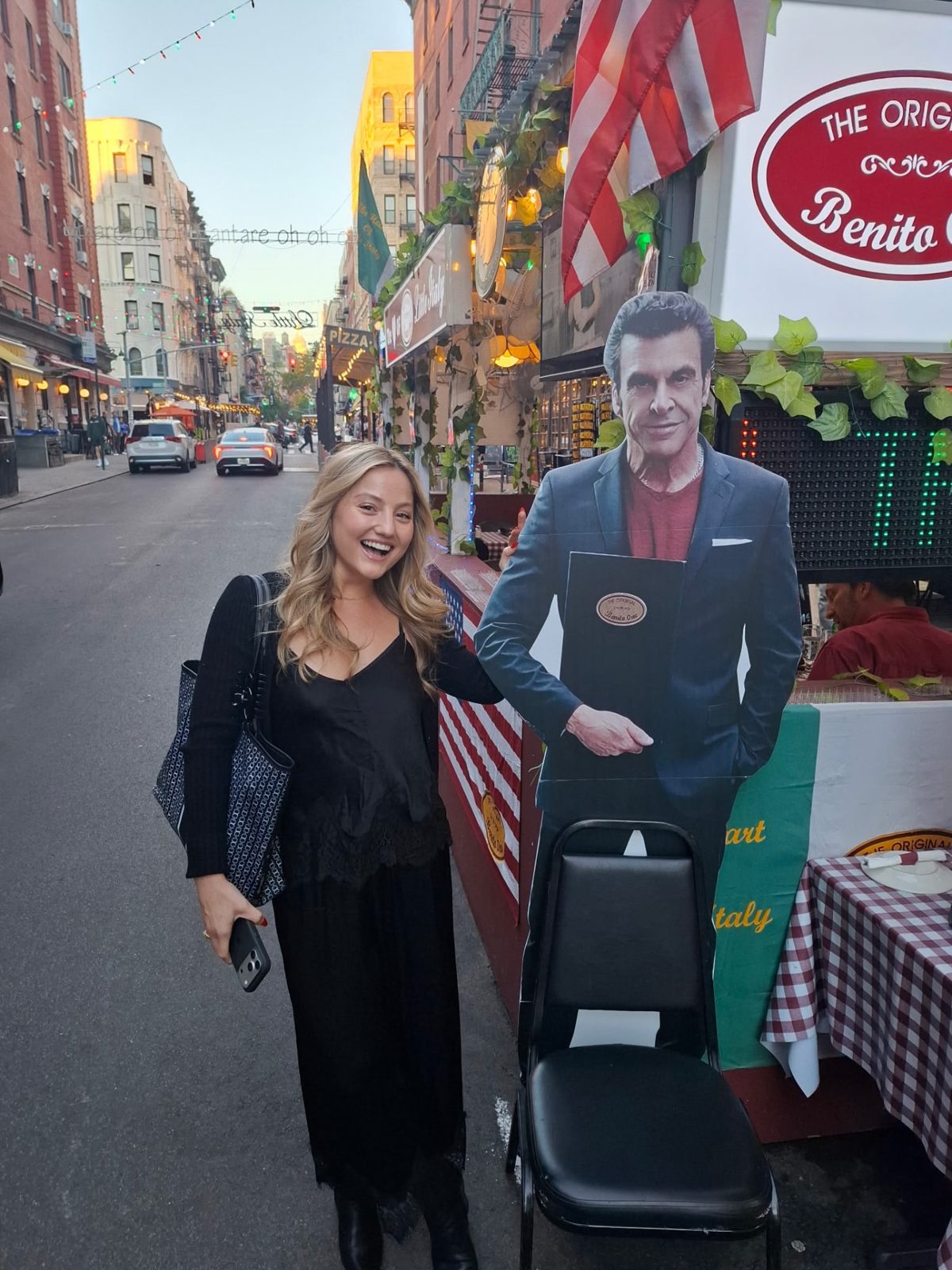 A guest posing beside the outdoor restaurant display